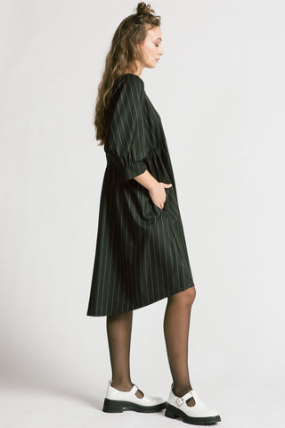 Side view of woman wearing black and white pinstripe relaxed babydoll Notebook dress by Allison Wonderland. 