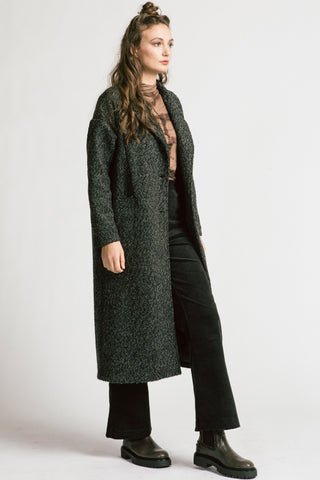 Side view of woman wearing grey bouclé oversized coat by Allison Wonderland. 