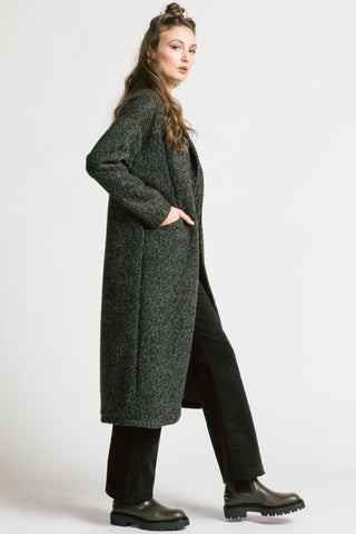 Side view of woman wearing grey bouclé oversized coat by Allison Wonderland. 