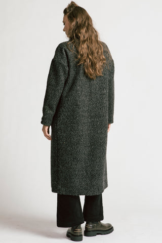 Back view of woman wearing grey bouclé oversized coat by Allison Wonderland. 