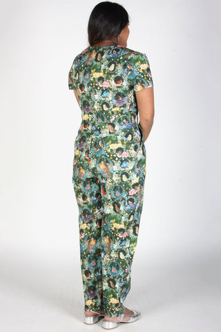 Back view of model wearing bird print short sleeve fitted Auk jumpsuit by Birds of North America. 