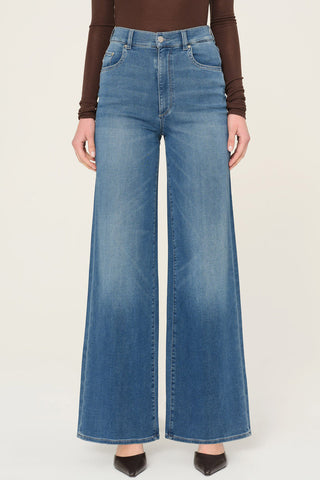 Woman wearing brown shirt and DL1961 Hepburn Wide Leg jeans in Mohong wash. 