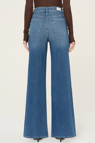 Back view of woman wearing brown shirt and DL1961 Hepburn Wide Leg jeans in Mohong wash. 