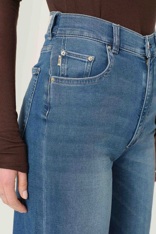 Close-up of waist of woman wearing brown shirt and DL1961 Hepburn Wide Leg jeans in Mohong wash. 