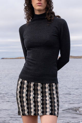 Model wearing grey turtleneck and stripe hand crocheted skirt by Dinadi.  