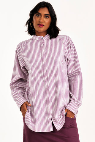 Woman wearing an oversized lilac purple and white seersucker stripe button up Adore shirt by Jennifer Glasgow. 