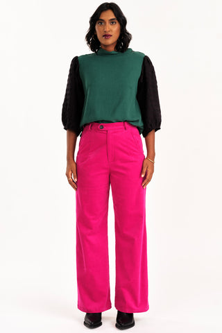 Woman wearing green and black top with 70s inspired high waist fucshia fine corduroy Diana pant by Jennifer Glasgow. 