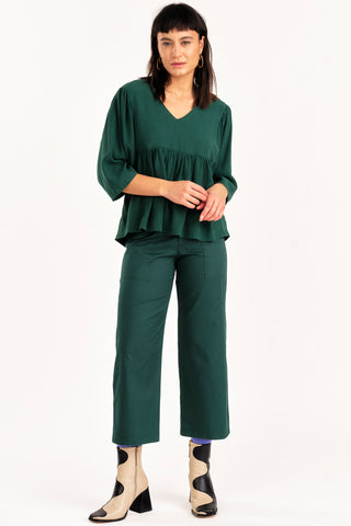 Woman wearing green top with green organic cotton cropped Elliot pants by Jennifer Glasgow. 