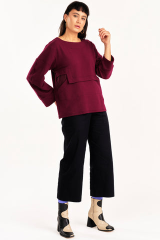 Woman wearing burgundy top with black organic cotton cropped Elliot pants by Jennifer Glasgow. 