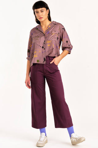 Woman wearing button up shirt with purple organic cotton cropped Elliot pants by Jennifer Glasgow. 