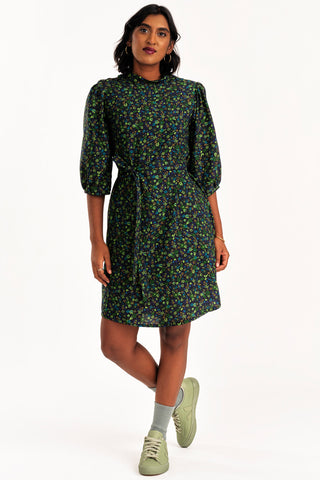 Woman wearing black and green floral print button up Enduring Dress by Jennifer Glasgow. 