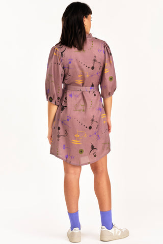 Back view of woman wearing purple crop circle print button up Enduring Dress by Jennifer Glasgow. 