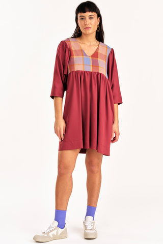 Woman wearing deep pink loose fitting empire waist Exalt dress by Jennifer Glasgow. 