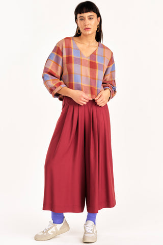 Woman wearing plaid shirt with auburn wide leg Harlow pants by Jennifer Glasgow. 