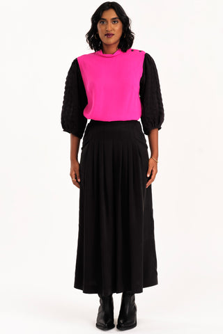 Woman wearing black and pink blouse with black wide leg Harlow pants by Jennifer Glasgow. 