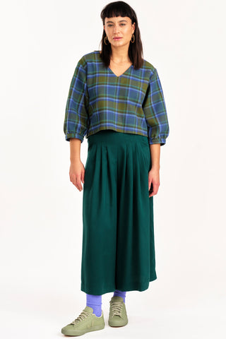 Woman wearing plaid shirt and green wide leg Harlow pants by Jennifer Glasgow. 