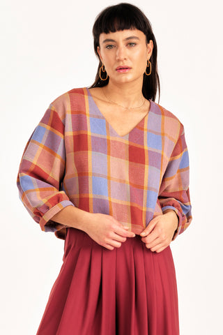 Woman wearing pink and lilac tone plaid v-neck Love top by Jennifer Glasgow. 