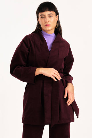 Woman wearing burgundy fine corduroy Orlop jacket by Jennifer Glasgow. 