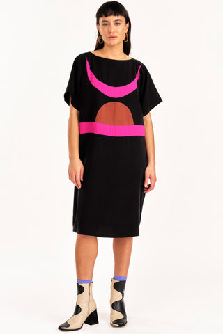 Woman wearing black and fuchsia colour blocked Rise tunic by Jennifer Glasgow. 