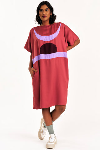 Woman wearing dark pink and lilac colour blocked Rise tunic by Jennifer Glasgow. 