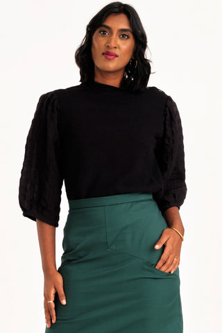 Woman wearing black mock neck Solace top by Jennifer Glasgow. 