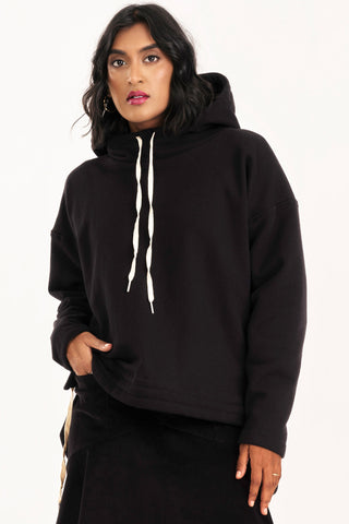 Woman wearing black hooded Valentia sweater by Jennifer Glasgow. 