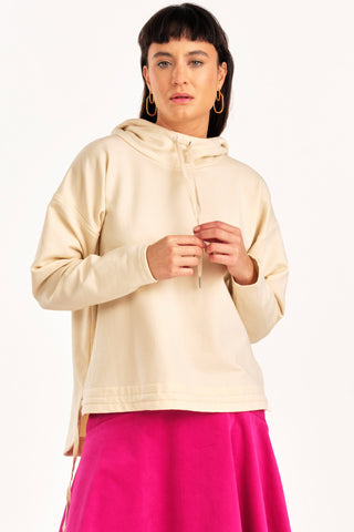 Woman wearing cream hooded Valentia sweater by Jennifer Glasgow. 