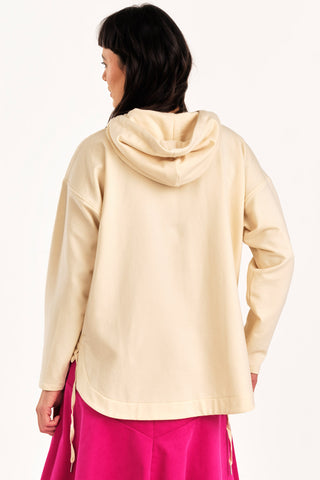 Back view of woman wearing cream hooded Valentia sweater by Jennifer Glasgow.