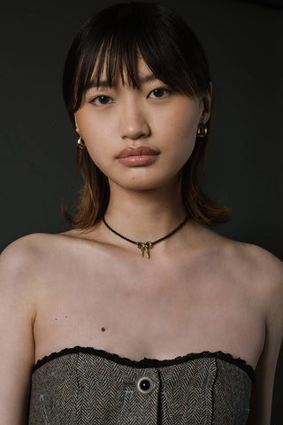 Woman wearing Kara Yoo black onyx Masie necklace. 