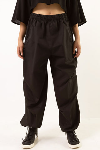 Model wearing black cotton twill Leap pants by Mercy House. 