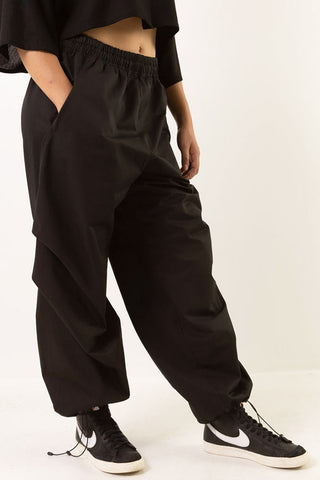 Model wearing black cotton twill Leap pants by Mercy House. 