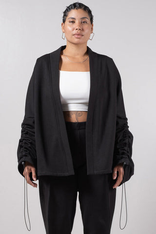 Model wearing black open front Sylas Cardigan by Mercy House. 