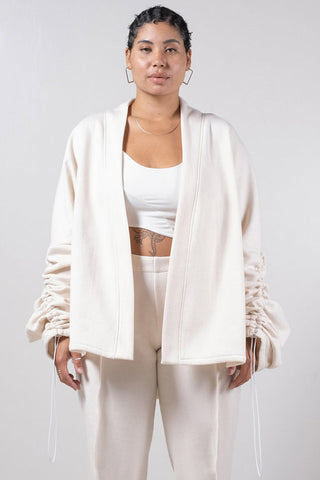 Model wearing white open front Sylas Cardigan by Mercy House. 