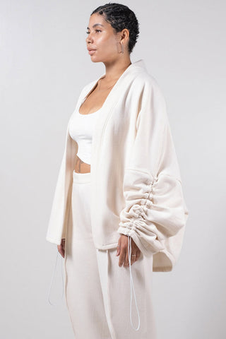 Model wearing white open front Sylas Cardigan by Mercy House. 