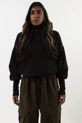 Model wearing black Telfar hoodie by Mercy House. 