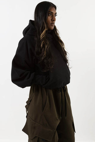 Model wearing black Telfar hoodie by Mercy House. 