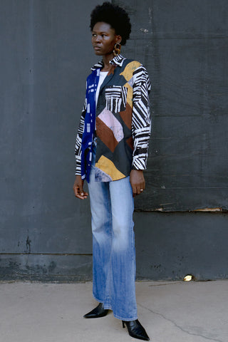 Woman wearing oversized multicolour button up batik print Bula shirt by Osei Duro. 