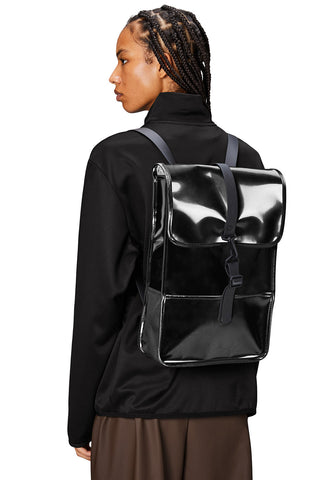 Woman wearing shiny black Night coloured unisex Backpack Mini by RAINS. 