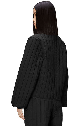 Back view of model wearing black quilted Banja Liner Bomber by RAINS. 