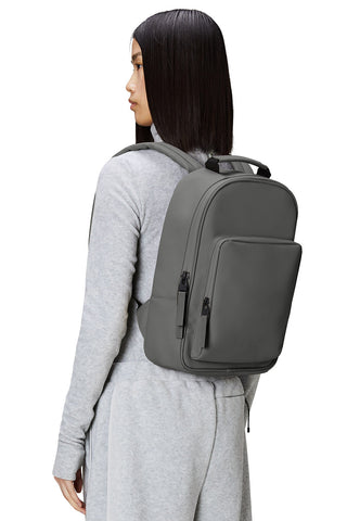 Woman wearing the grey RAINS Book Daypack W3. 