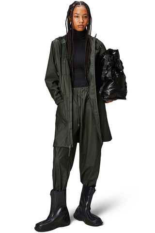 Model wearing green waterproof Cargo Curved Jacket by Rains. 