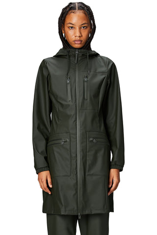 Model wearing green waterproof Cargo Curved Jacket by Rains. 