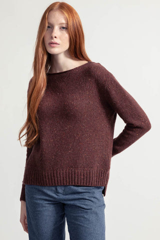 Model wearing orange flecked recycled cashmere Eloisa sweater by Rifo. 