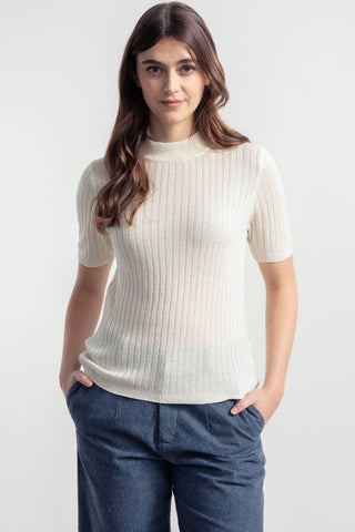 Woman wearing ivory recycled silk Renza top by Rifo. 