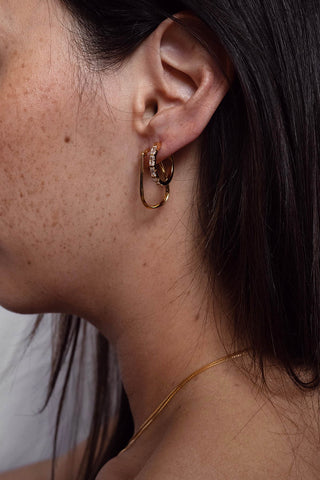 Model wearing gold old Lyn hopp earrings by Sarah Mulder. 