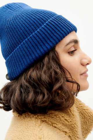 Model wearing blue wool Amor beanie by Thinking Mu. 