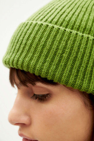 Close-up of model wearing green wool Amor beanie by Thinking Mu. 