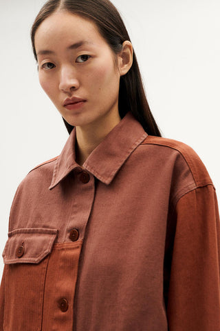 Close-up of model wearing brown hemp & organic cotton Zaha jacket by Thinking Mu. 