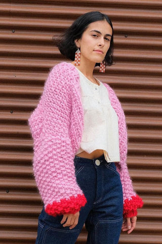 Woman wearing pink and red chunky knit merino wool cardigan by Toast & Yam. 