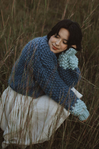 Woman wearing blue chunky knit merino wool Cutie Sweater by Toast & Yarn. 